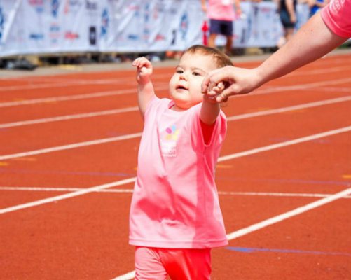 Mia on a running track holding her mum&amp;#39;s hand during the British Transplant Games.