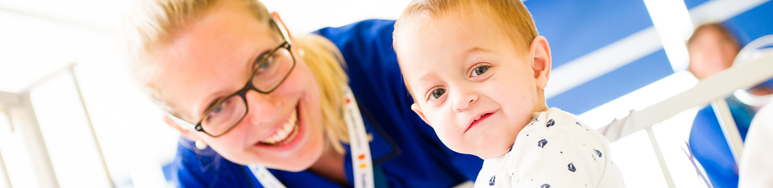 Nurse with toddler in cot