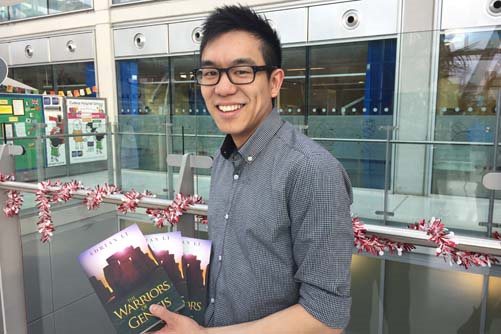 Adrian Li holds up his book, The Warriors of Genesis