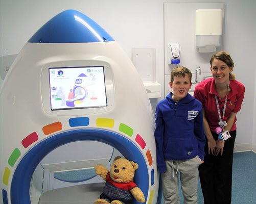 Young boy and play specialist with play MRI scanner