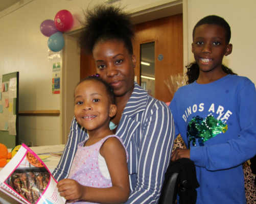 A mother and her two children reading our new book, Together We Cook.