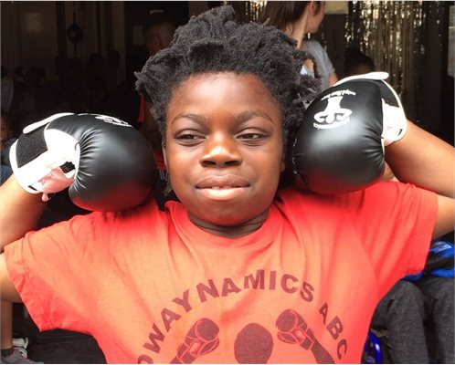 Young boy posing wearing boxing gloves