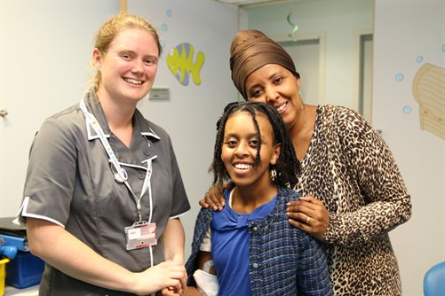 Young patient Rewina Tsegai smiling with mum and nurse