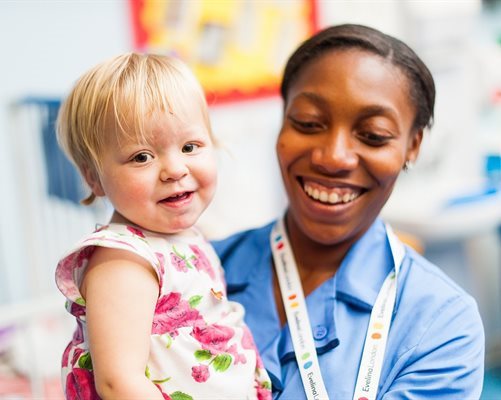 Nurse holding little girl smiling