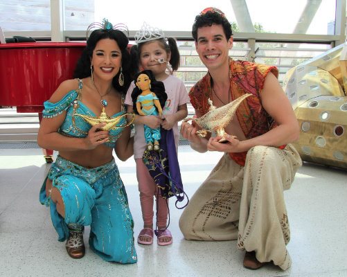 Aladdin and Jasmine with one of our patients, who is wearing a tiara and holding a Jasmin doll at Evelina London