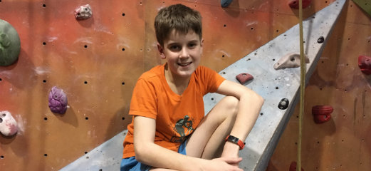 Matthew by a climbing wall.