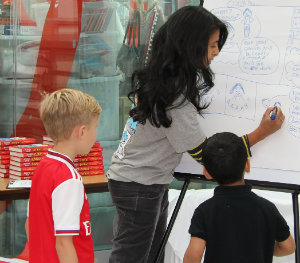 Konnie Huq drawing on a board near two patients.