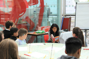 Konnie Huq reading her book to a group of patients