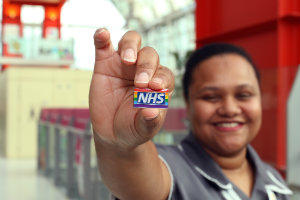 An Evelina London nurse holding an NHS Rainbow Badge