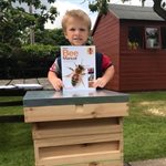 Samuel holding a manual about keeping bees.