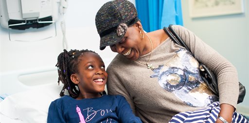 Mum and young girl on hospital bed