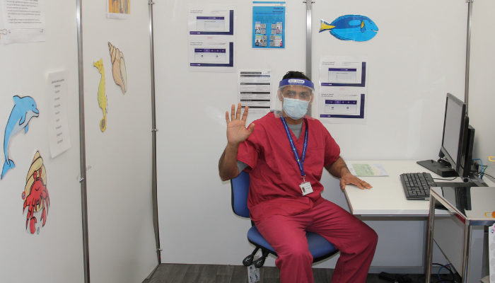 Vaccinator with PPE waving
